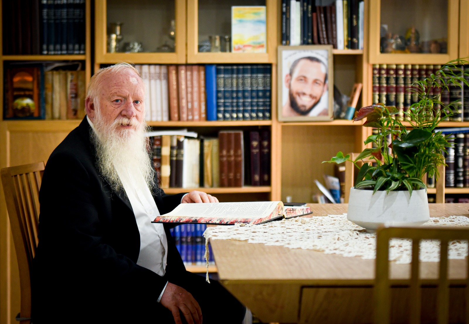 "אנחנו מכירים במעלה העצומה שיש בצורה שבה עמיחי הסתלק וזה נותן לנו הרבה כוח". הרב יוסף ויצן ותמונת הבן עמיחי הי"ד. צילום: ניצי אילן