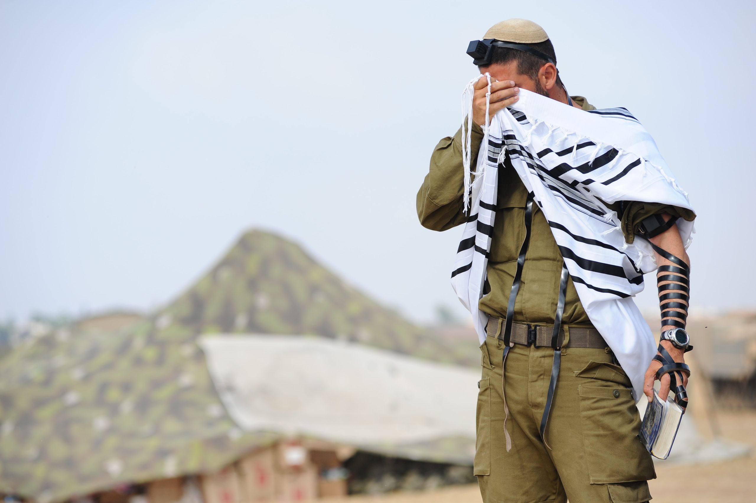 חייל דתי מתפלל שחרית סמוך לגבול עזה בזמן מבצע צוק איתן. קרדיט: מנדי הכטמן \ פלאש 90
