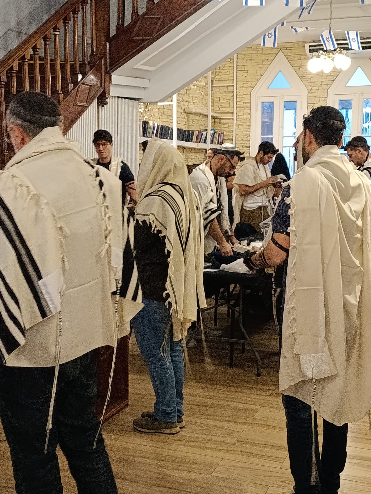 תקרת בית הכנסת מעוטרת בדגלי ישראל. תפילת שחרית של חול בקהילת 'לה קאסה'. צילום: עמנואל שילה